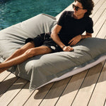 Pouf géant flottant gris galet de 180x140 cm, en billes, pour piscine, de marque Deco-arts.fr, déhoussable et confortable.