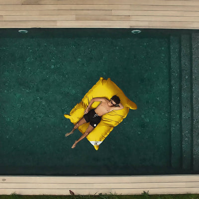 Pouf géant flottant jaune miel de 180x140 cm, en billes, pour piscine, de marque Deco-arts.fr, déhoussable et XXL.