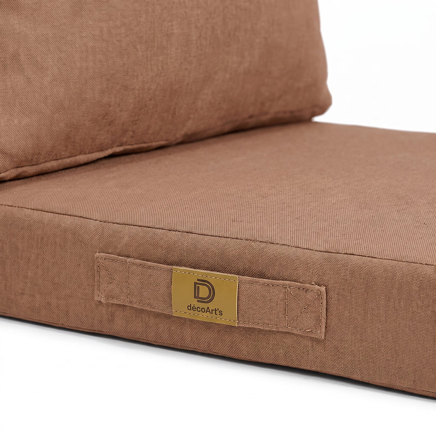 Close-up van het handvat en het Deco Arts-label op het kussen met linnenlook in Terracotta