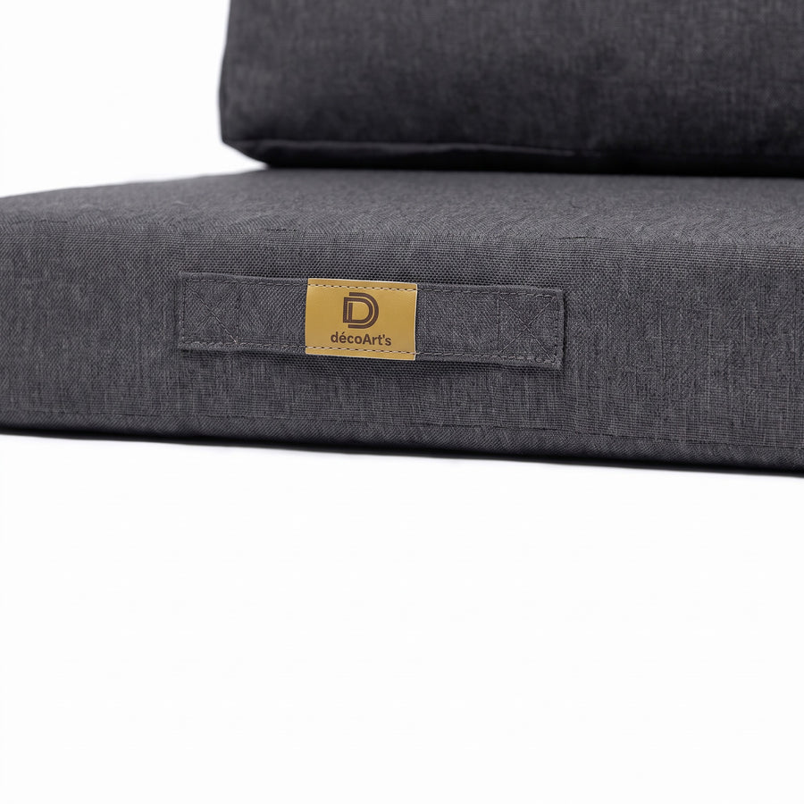 Close-up van het handvat en het Deco Arts-label op het kussen met linnenlook in Gemêleerd Grijs