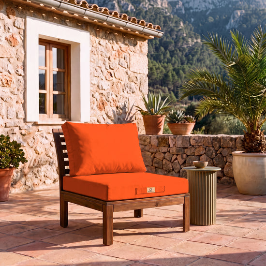 Conjunto de almofadas para sala de jardim 50x50 Laranja numa poltrona de madeira, terraço de uma finca maiorquina