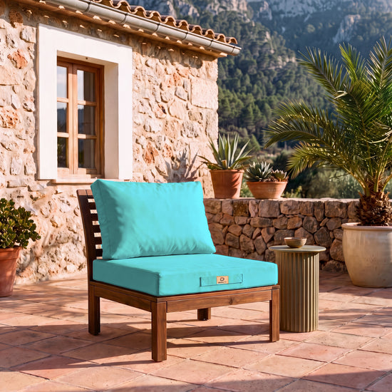 Ensemble coussins salon de jardin 60x70 Bleu Caraïbes sur un fauteuil en bois, terrasse d&