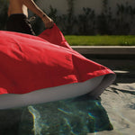 Pouf géant flottant en billes rouge piment, pour piscine, de marque Deco-arts.fr, dimensions 180x140 cm, déhoussable et confortable.