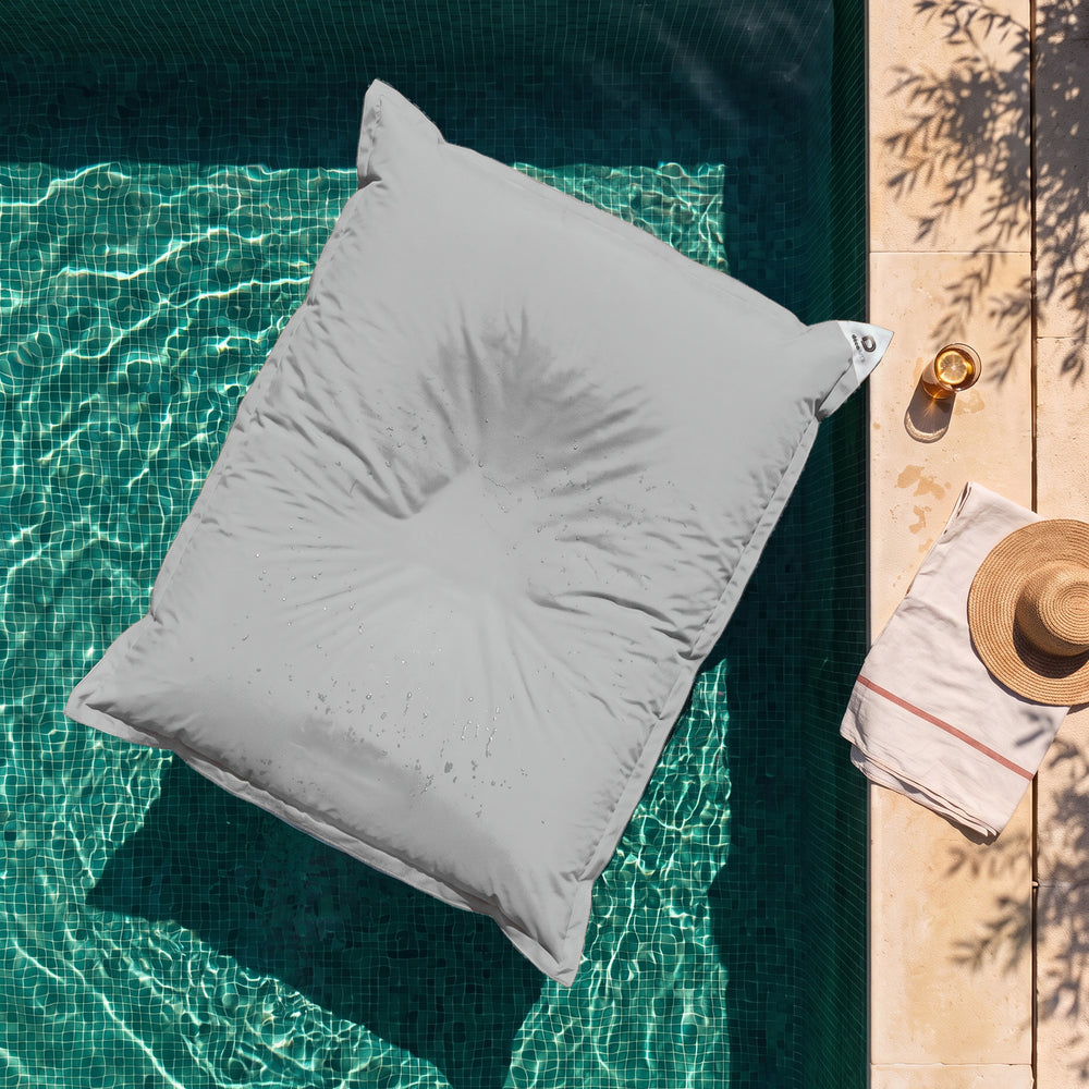 Housse seule à garnir – Pouf géant flottant Gris Galet sur l'eau d'une piscine, vue du dessus